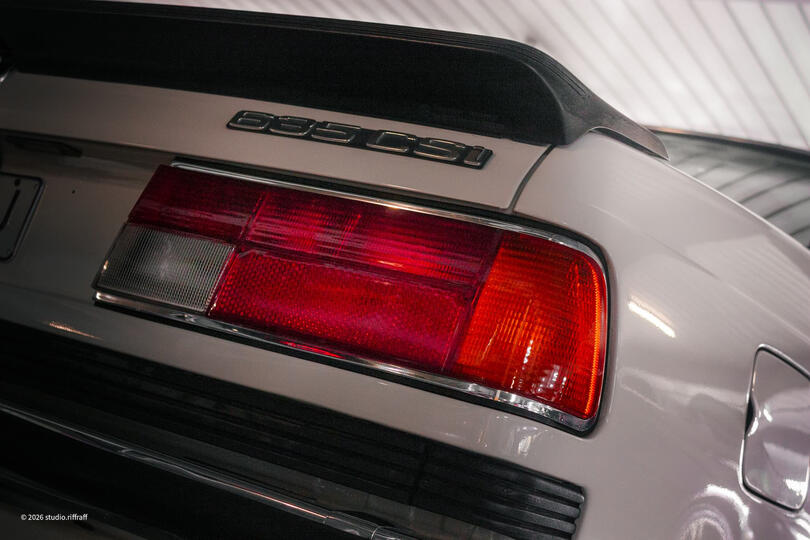 Untitled A white BMW E24 635CSi in a parking garage, lit by the morning light